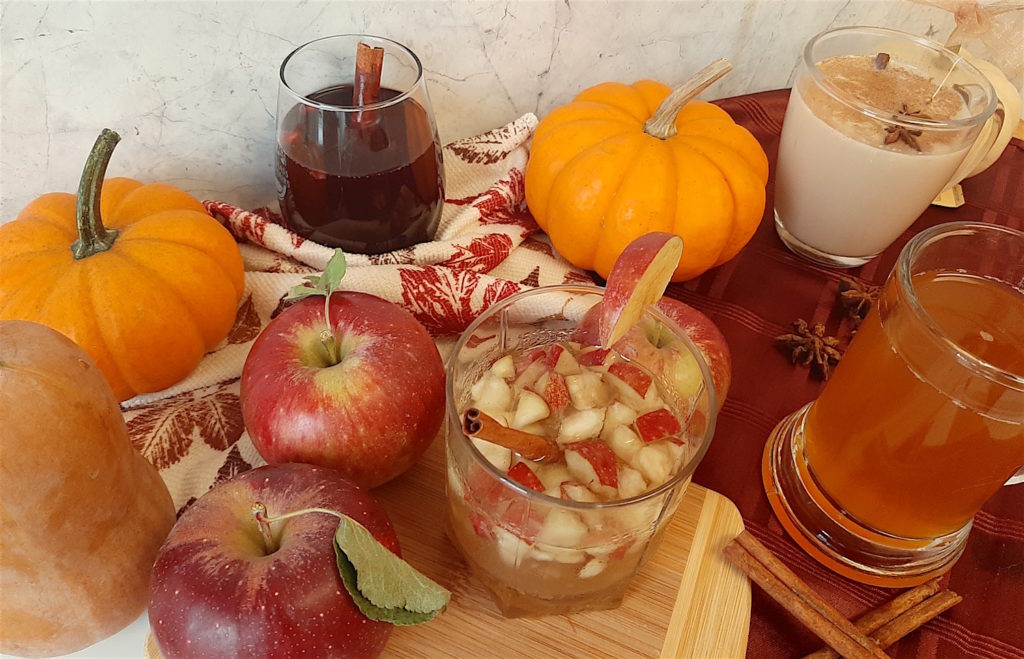 Fall cocktails on display with pumpkins, squash, apples, and fall spices.