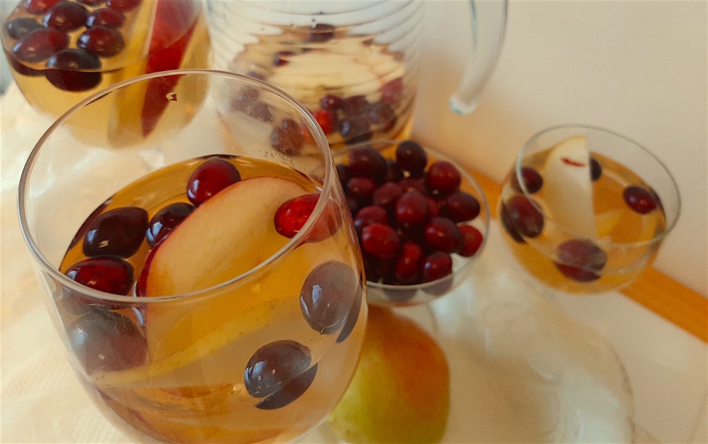 White Wine Sangria with Cranberries, Apples, and Pears. Surrounded by Cranberries, Apples and Pears. Fall Cocktail. Thanksgiving Cocktail. Big batch cocktail.