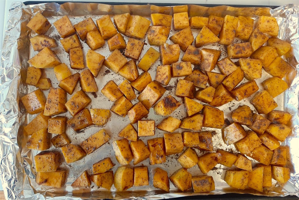 Cookie sheet of unroasted, seasoned butternut squash ready to go in the oven.