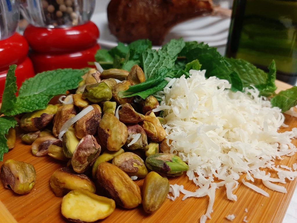 Pistachio and mint crust ingredients: pistachios, mint, gruyere, cardamom, salt, pepper, olive oil. Seared Lamb Rack in the background.