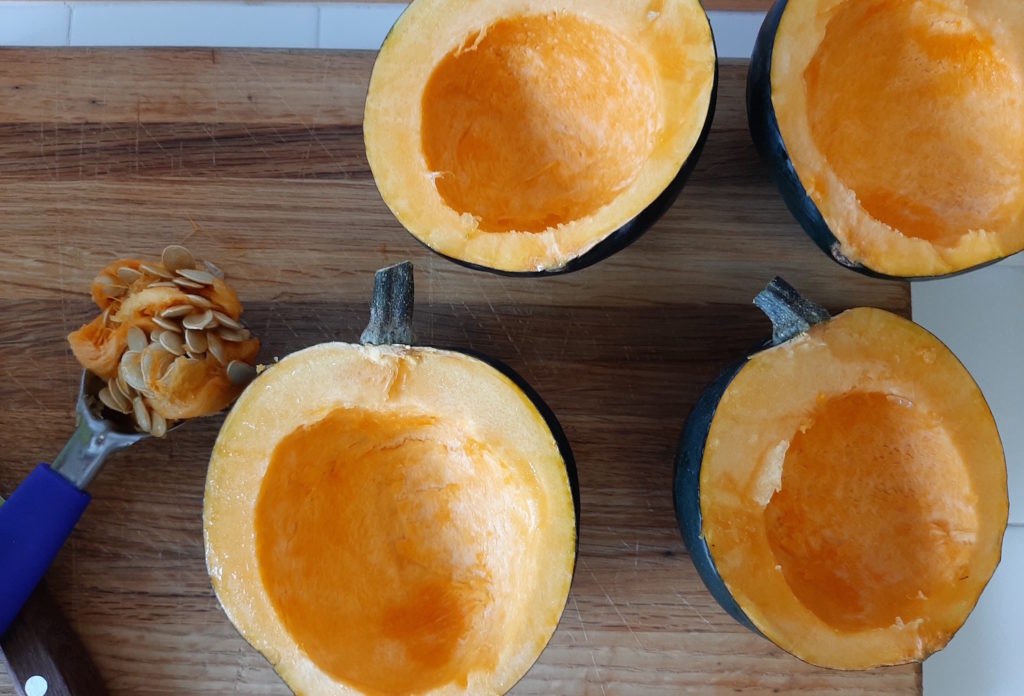 Two halved acorn squash with seeds removed