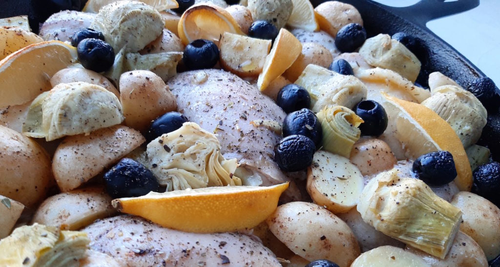 Oven Roasted Chicken Thighs with Potatoes, Artichokes, Olives, Lemons, Wine, Broth in a large Cast Iron Skillet