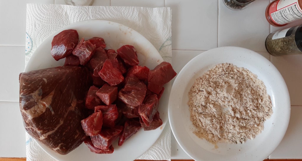 Beef stew meat and beef loin roast with coconut flour, paprika, pepper, salt, and marjoram waiting to be coated