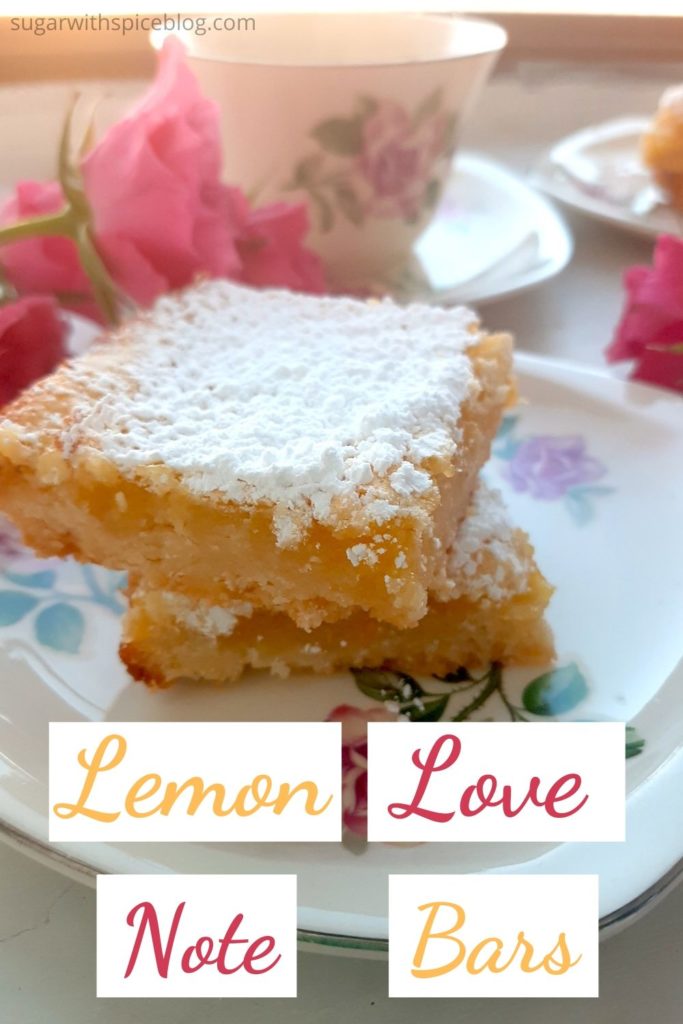Lemon Love note pinterest image. Two Lemon Bars on a rose tea saucer with pink spray roses and rose tea cup and saucer in the background on a window sill. Sugar with Spice Blog.
