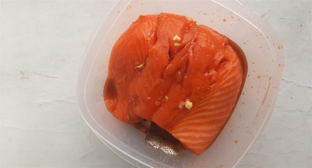 Raw Salmon marinating in honey wasabi sauce in a tupperware. Sugar with Spice Blog.