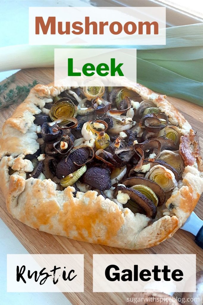 Overhead shot of Mushroom Leek Galette with goat cheese and thyme wrapped in all butter crust on a wooden cutting board. Surrounded by leeks, thyme and mushrooms and held by a pastry cutter. Pinterest Image. Sugar with Spice Blog.