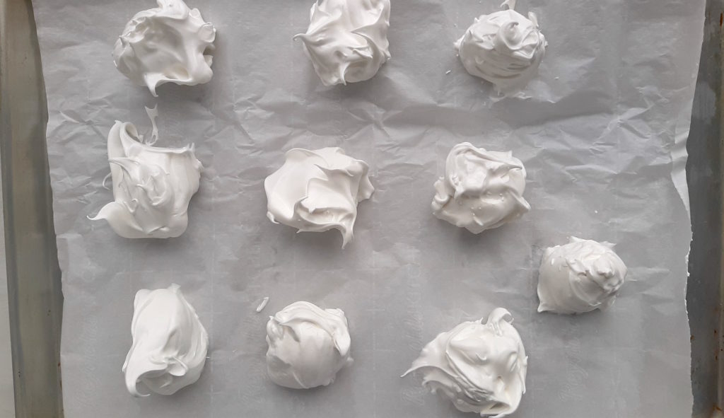 Homemade meringues on parchment paper. Sugar with Spice Blog.