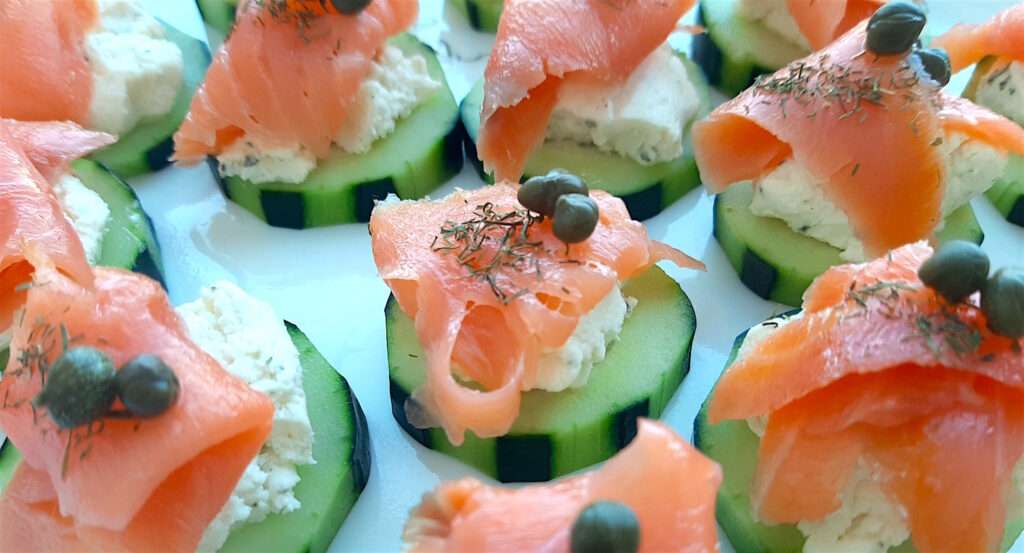 Cucumber Smoked Salmon Bites on a white serving tray with boursin cheese, capers, and smoked salmon. Close up shot. Sugar with Spice Blog.