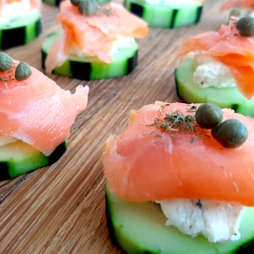 Cucumber Smoked Salmon Bites on a wooden cutting board with boursin cheese, capers, and smoked salmon. Close Up shot. Sugar with Spice Blog.
