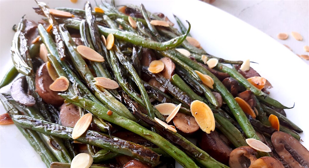 Almond and Mushroom Green Beans served on a white serving dish. Close Up shot. Sugar with Spice Blog.