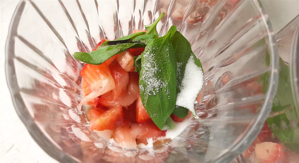 Balsamic Strawberry Basil Mojito ingredients in a tumbler to be muddled: fresh strawberries, fresh basil, sugar,. Overhead close up shot. Sugar with Spice Blog.