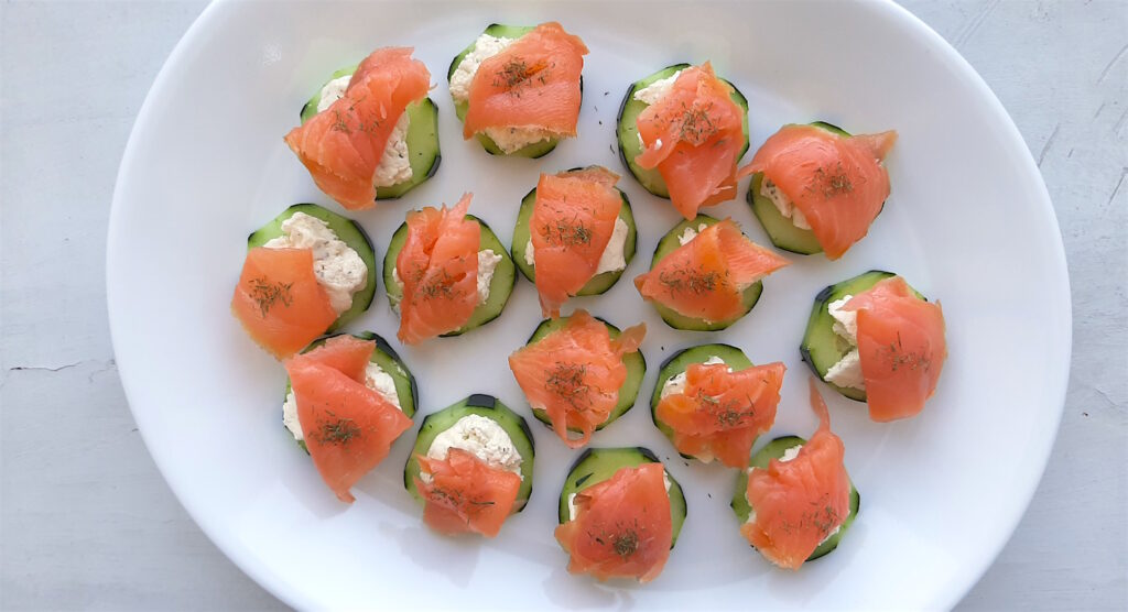 Cucumber Smoked Salmon Bites on a white serving tray with boursin cheese, capers, and smoked salmon. Overhead shot. Sugar with Spice Blog.
