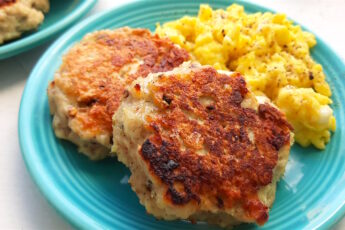 Homemade turkey sausages on a blue plate with creamy scrambled eggs on a white window sill. Close up shot. Sugar with Spice Blog.