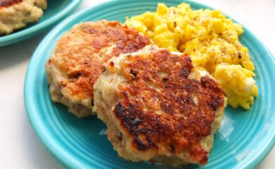 Homemade turkey sausages on a blue plate with creamy scrambled eggs on a white window sill. Close up shot. Sugar with Spice Blog.