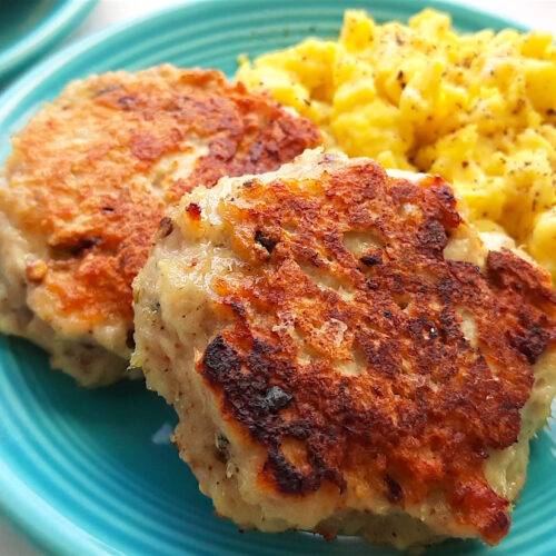 Homemade turkey sausages on a blue plate with creamy scrambled eggs on a white window sill. Close up shot. Sugar with Spice Blog.