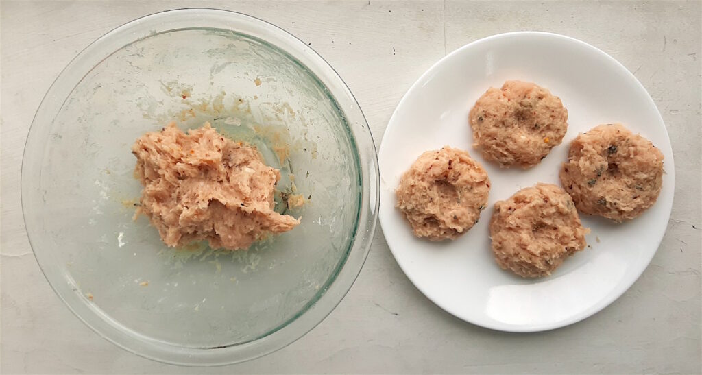 Shaping homemade turkey sausages. Shaped sausages on a white plate, mixed sausages in a pyrex bowl. White background. Sugar with Spice Blog.