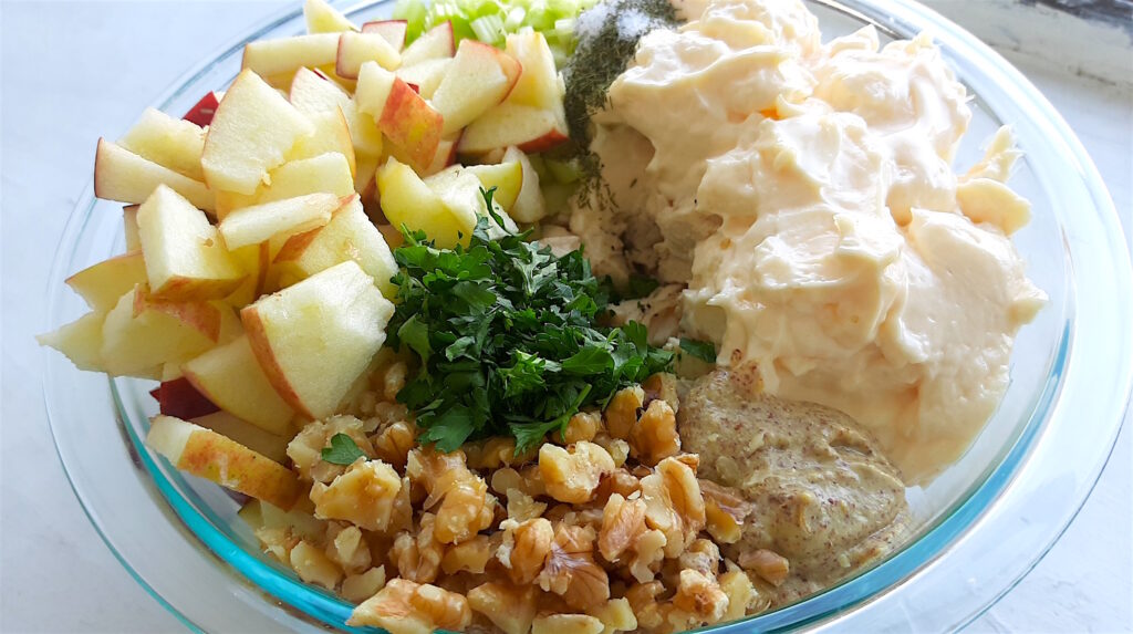 Chicken Salad with Apples and Walnuts uncombined in a pyrex dish on a white window sill. Sugar with Spice Blog.