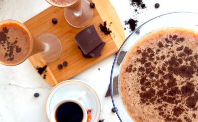 Mocha Martini Recipe Sugar with Spice Blog, One large mocha martini on a white background with espresso powder and chocolate chips in the background. Two smaller mocha martinis on a wooden cutting board with chocolate and an espresso in a white cup and saucer with dried flowers to the side.