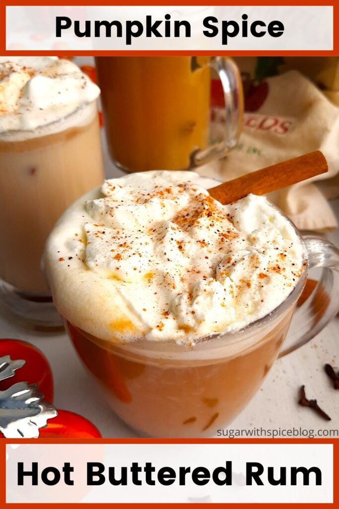 Three glasses of pumpkin spice hot buttered rum topped with whipped cream, cinnamon sticks, and ground nutmeg on a white windowsill. Window sill decorated with ceramic pumpkins, whole cloves, whole cinnamon sticks, ground nutmeg, and orange or fall-themed dish towels. Front Shot. Sugar with Spice blog. Pinterest Image. Black text reading "Hot buttered rum pumpkin spice" on white paneling with orange outline.